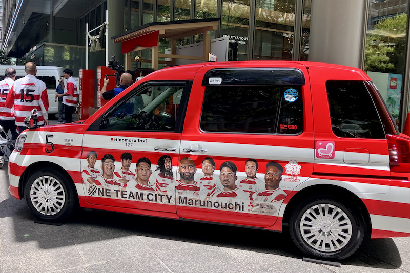 赤×白と、リーチらの顔、顔、顔。日本代表特別仕様タクシー「ONE TEAM TAXI」が運行中