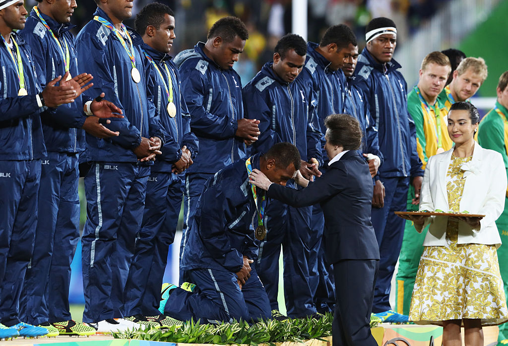 表彰式。フィジーの大男たちは膝を落とし、アン王女から金メダルをもらった（C）Getty Images
